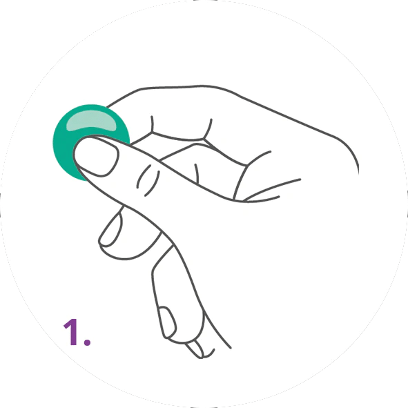 Hand hält eine kleine runde grüne Tablette zwischen Daumen und Zeigefinger, Schritt 1