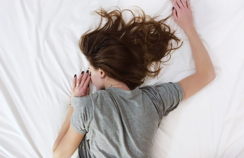 Frau liegt im Bett und schläft nachts besser