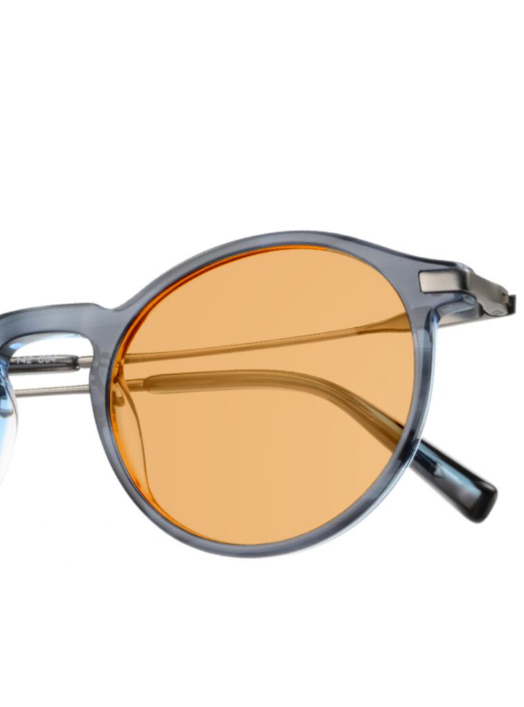 Runde transparent blaue Brille mit orange getönten Gläsern und Metallsteg, Nahaufnahme des rechten Glases