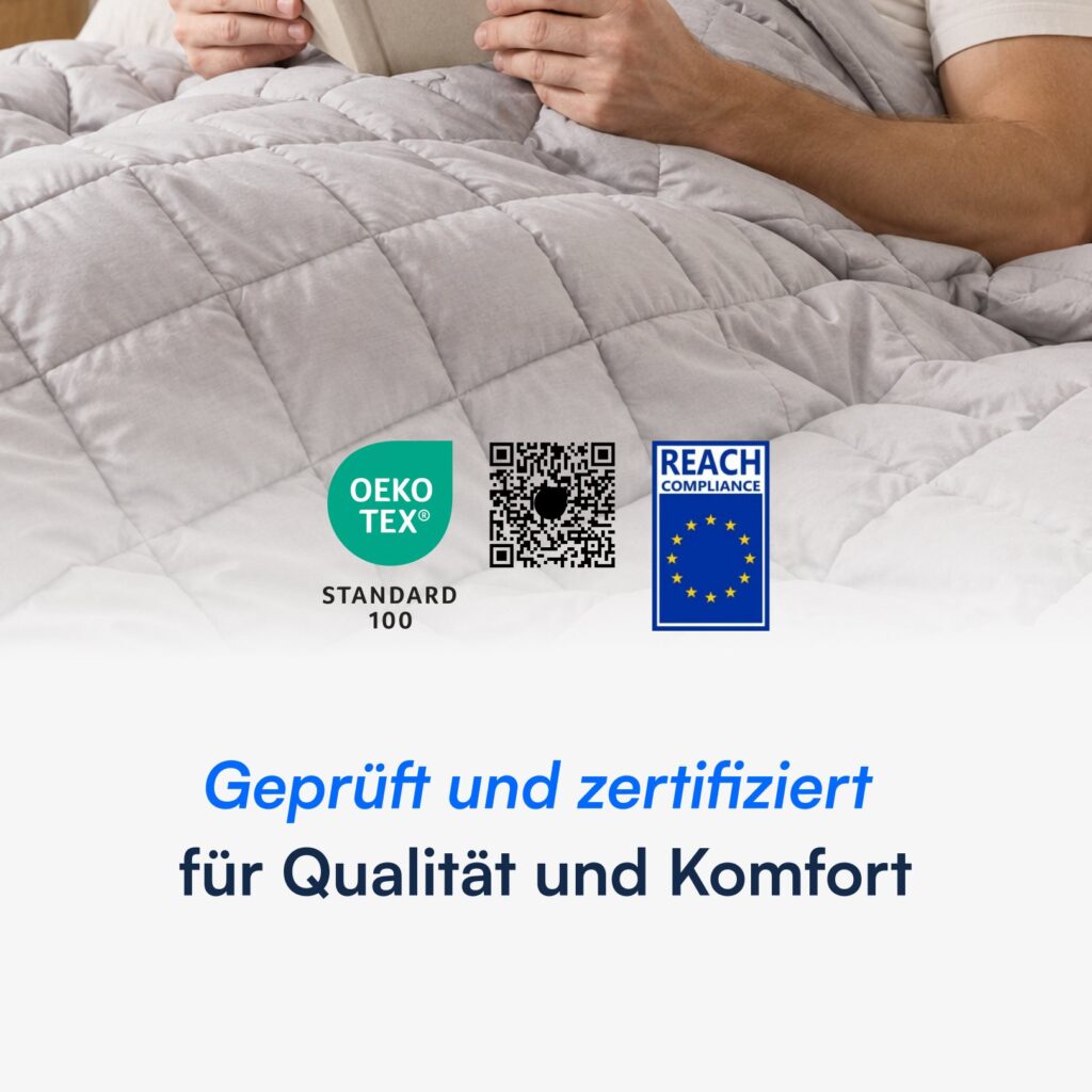Person liest unter hellgrauer gewichteter Bettdecke mit OEKO‑TEX‑ und REACH‑Prüfzeichen